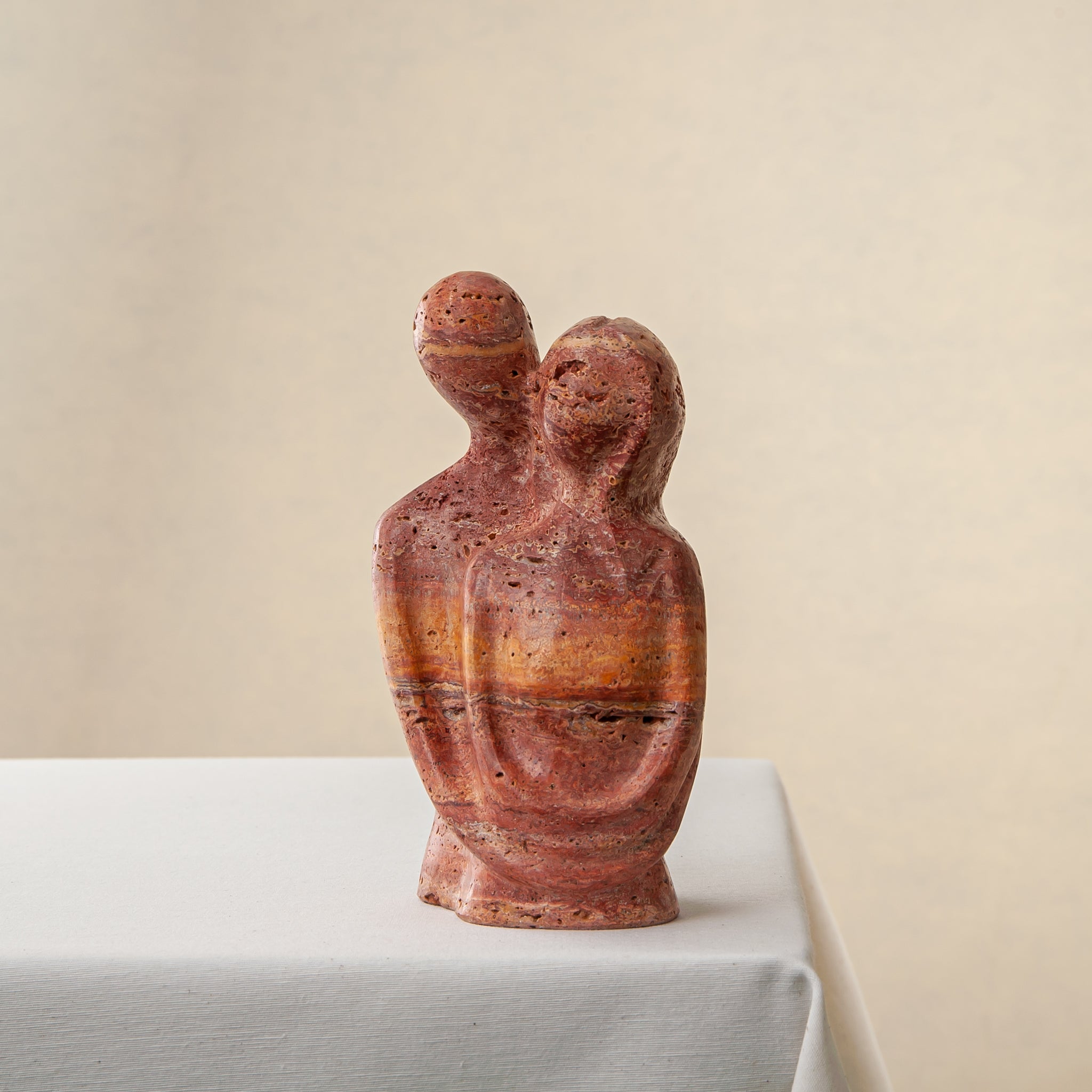 handcrafted travertine sculpture organic texture red stone intimate form interior styling
