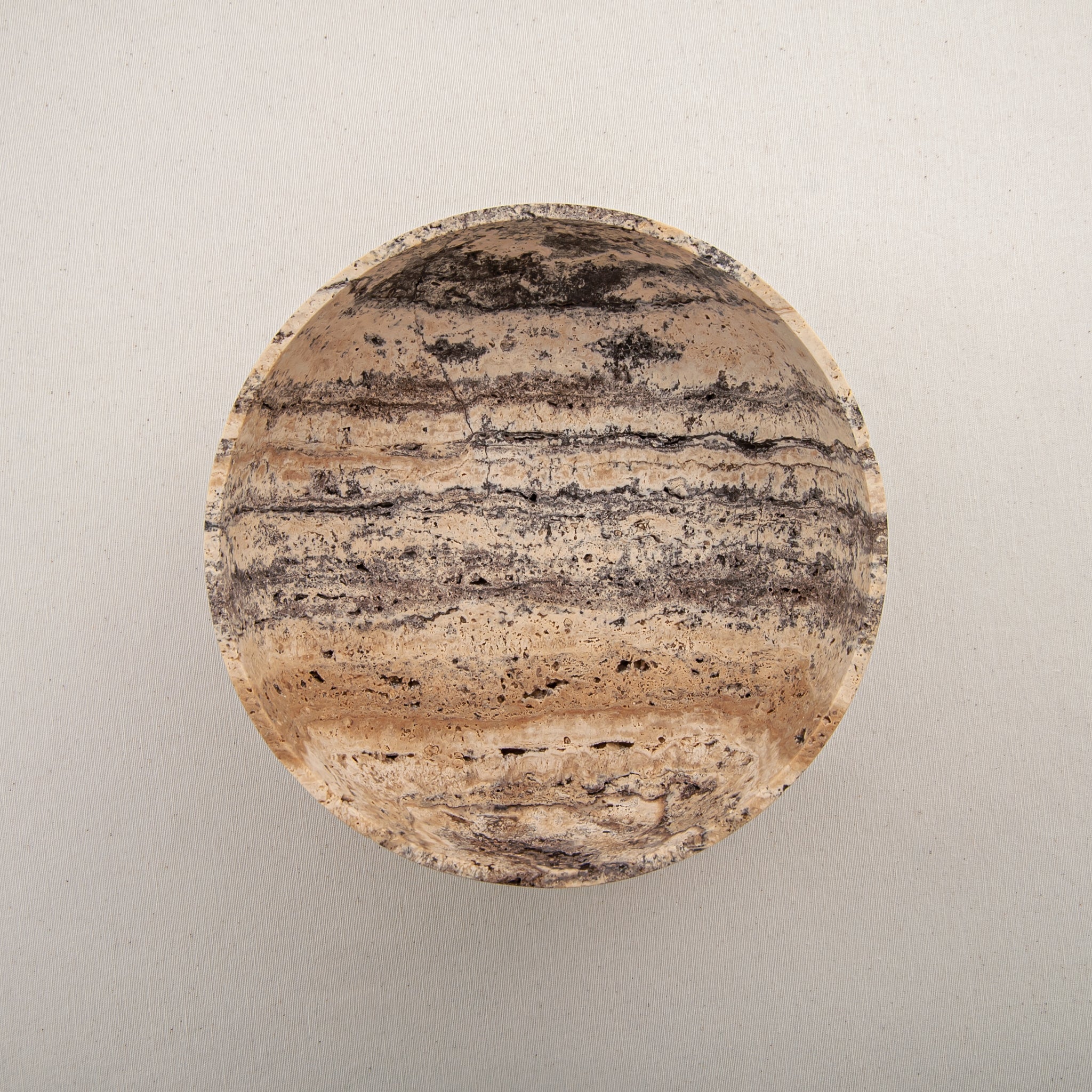 Handcrafted Gaia travertine bowl with wide shallow basin and pedestal base, featuring natural stone veining, by Uniiqo Studio