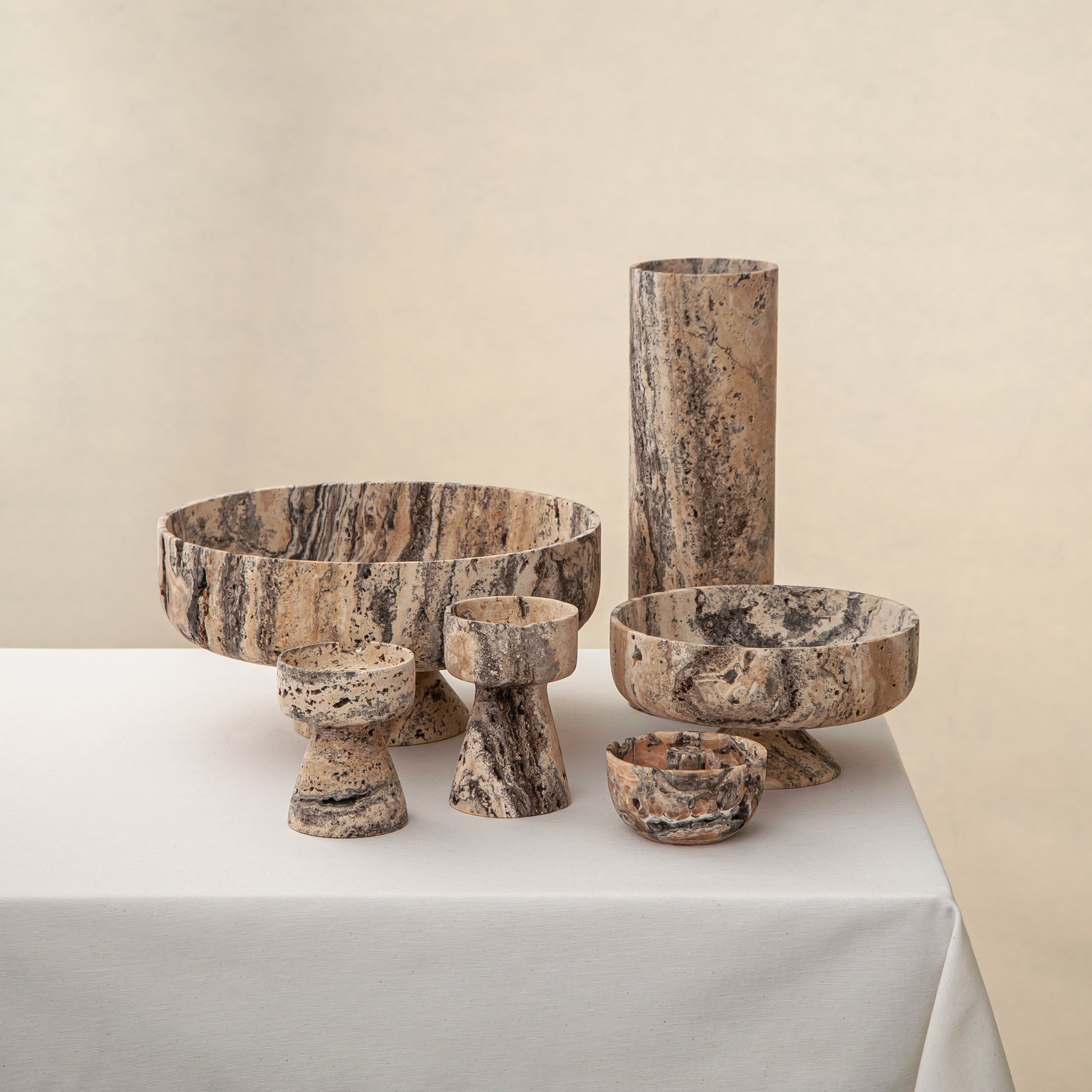 Handcrafted Gaia travertine bowl with wide shallow basin and pedestal base, featuring natural stone veining, by Uniiqo Studio