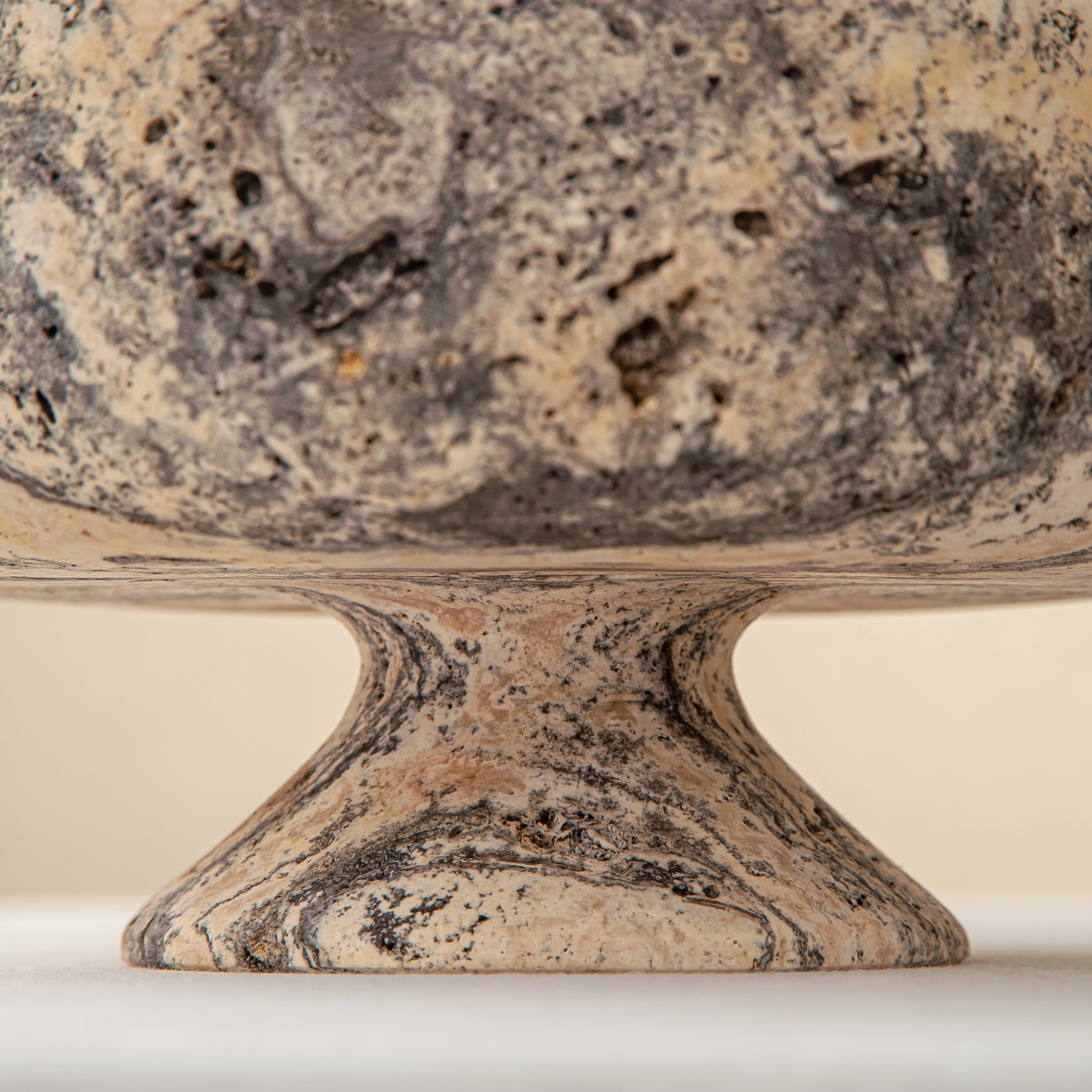 Handcrafted Gaia travertine bowl with wide shallow basin and pedestal base, featuring natural stone veining, by Uniiqo Studio