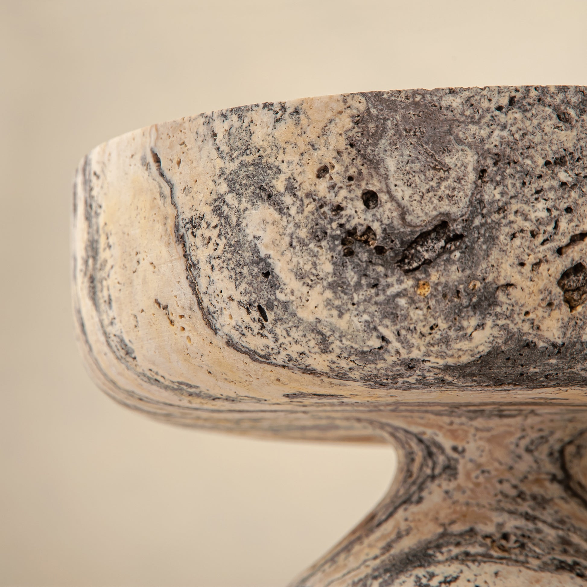 Handcrafted Gaia travertine bowl with wide shallow basin and pedestal base, featuring natural stone veining, by Uniiqo Studio