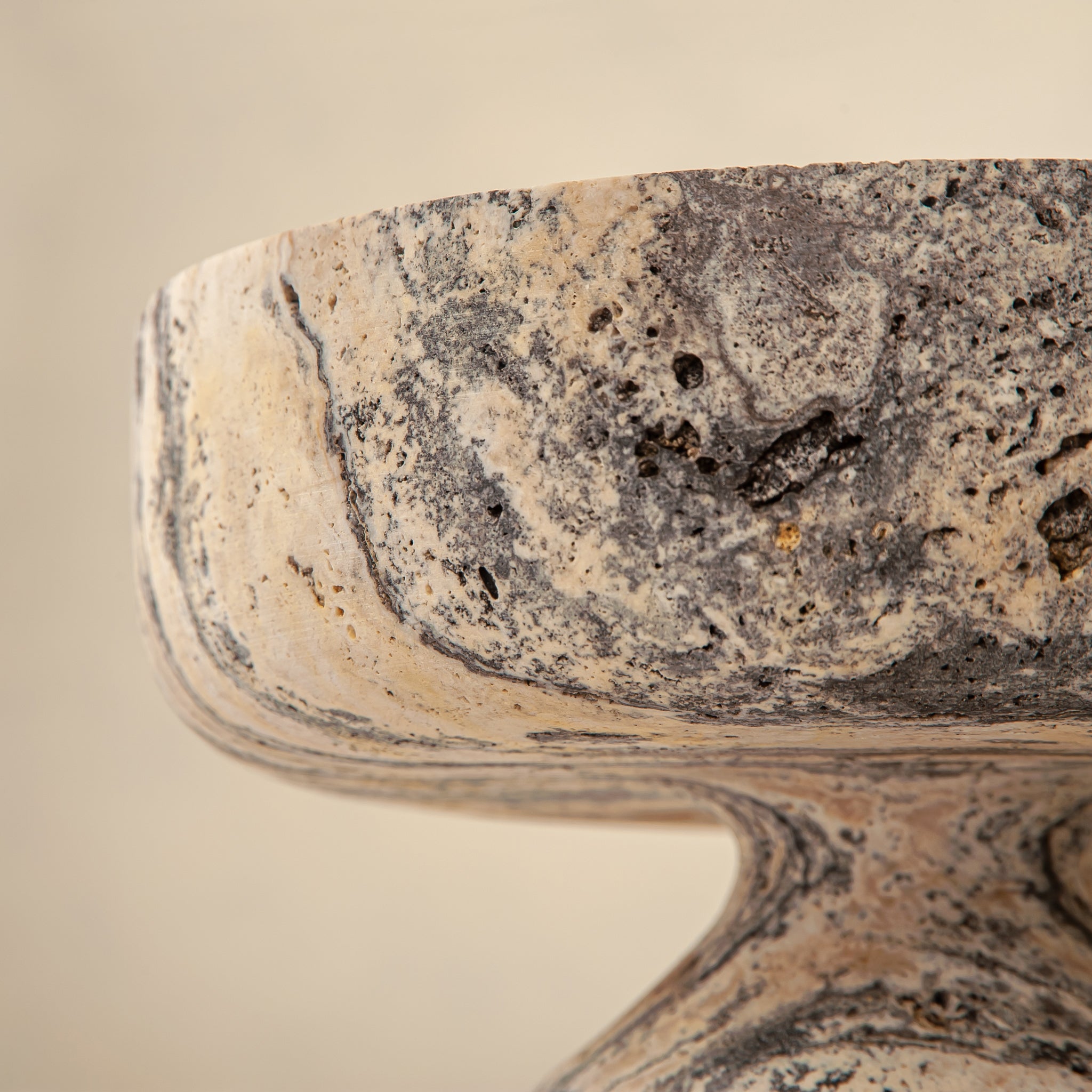 Handcrafted Gaia travertine bowl with wide shallow basin and pedestal base, featuring natural stone veining, by Uniiqo Studio