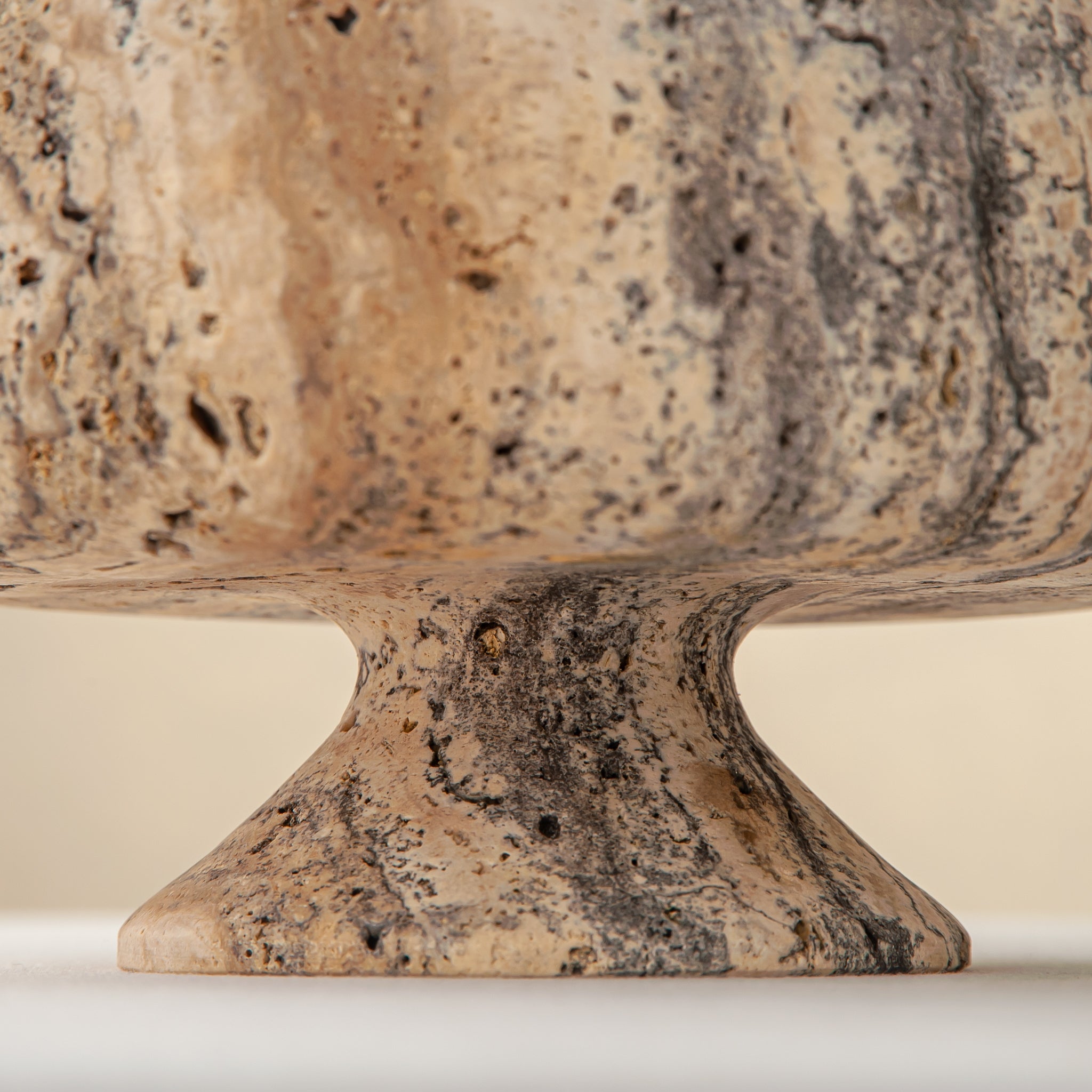 Handcrafted Gaia travertine bowl with wide shallow basin and pedestal base, featuring natural stone veining, by Uniiqo Studio