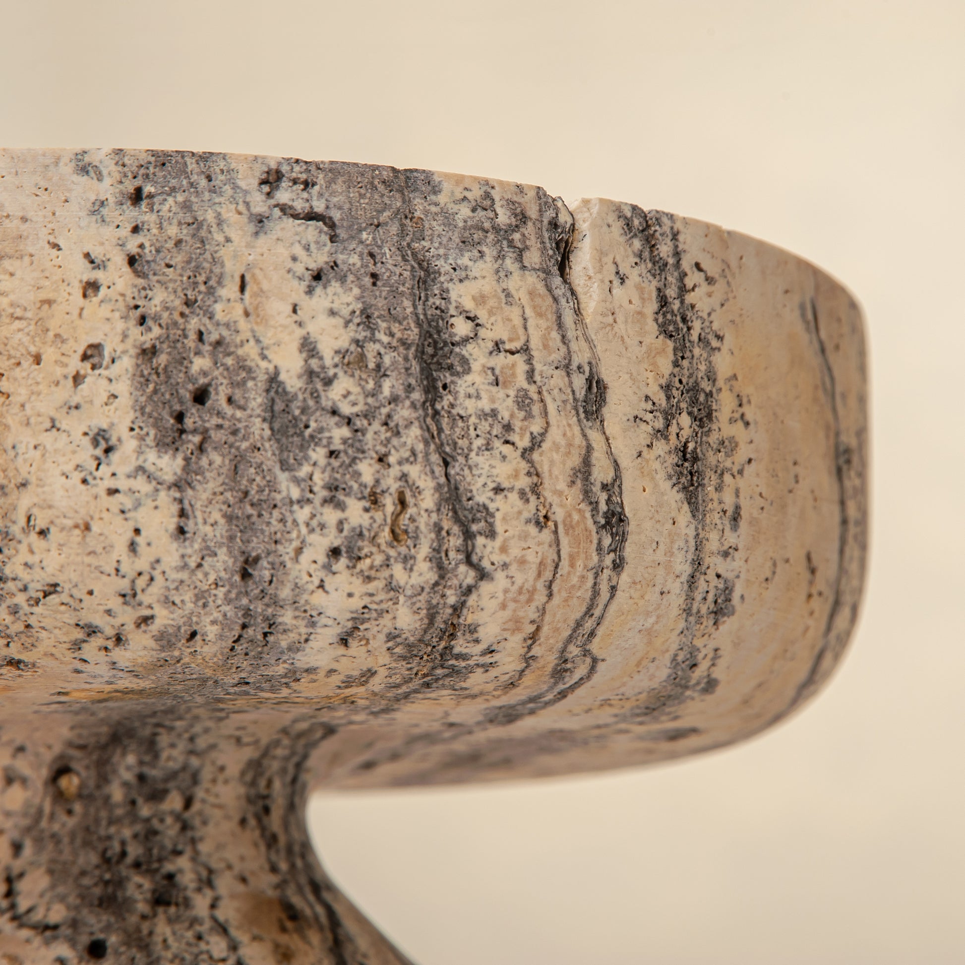 Handcrafted Gaia travertine bowl with wide shallow basin and pedestal base, featuring natural stone veining, by Uniiqo Studio