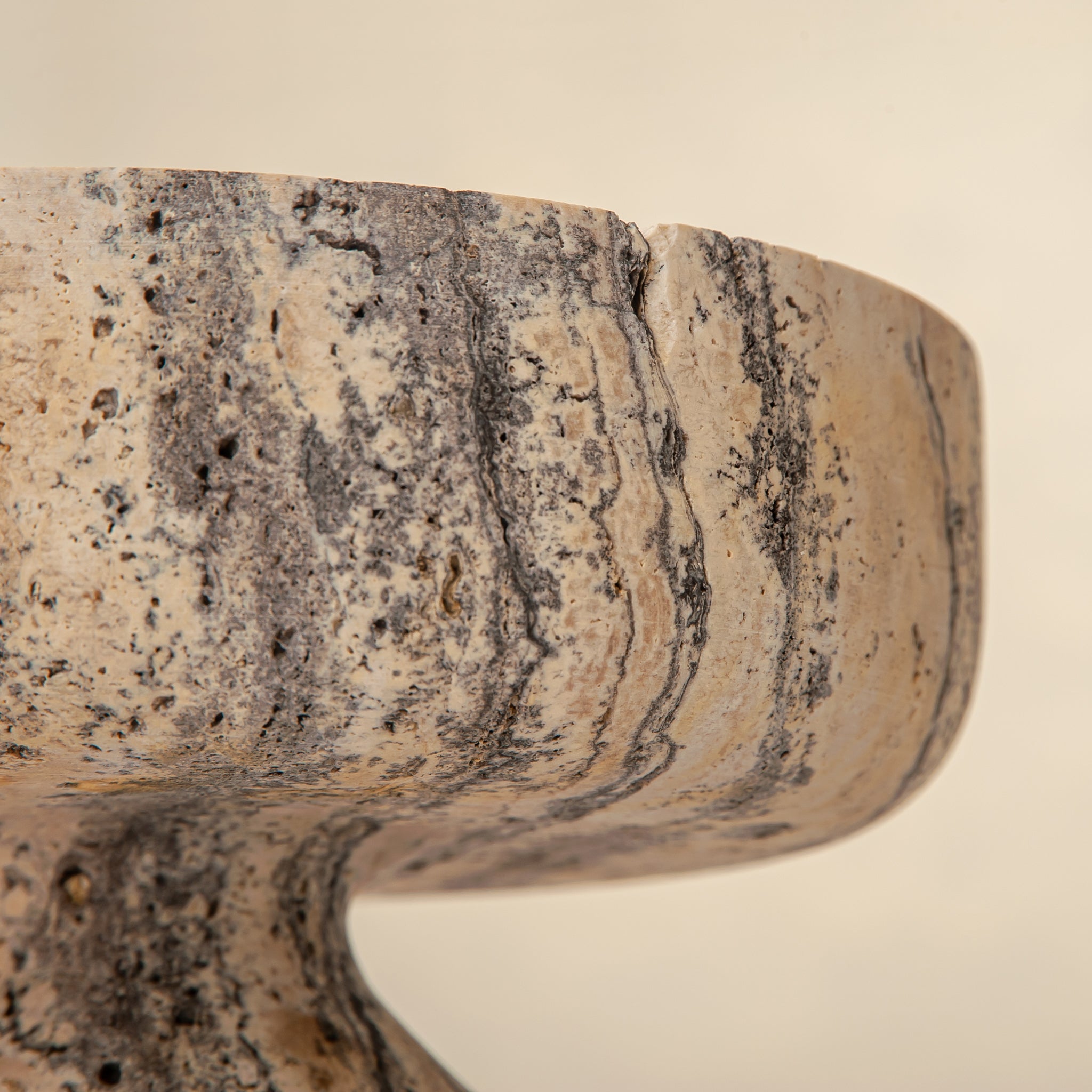 Handcrafted Gaia travertine bowl with wide shallow basin and pedestal base, featuring natural stone veining, by Uniiqo Studio