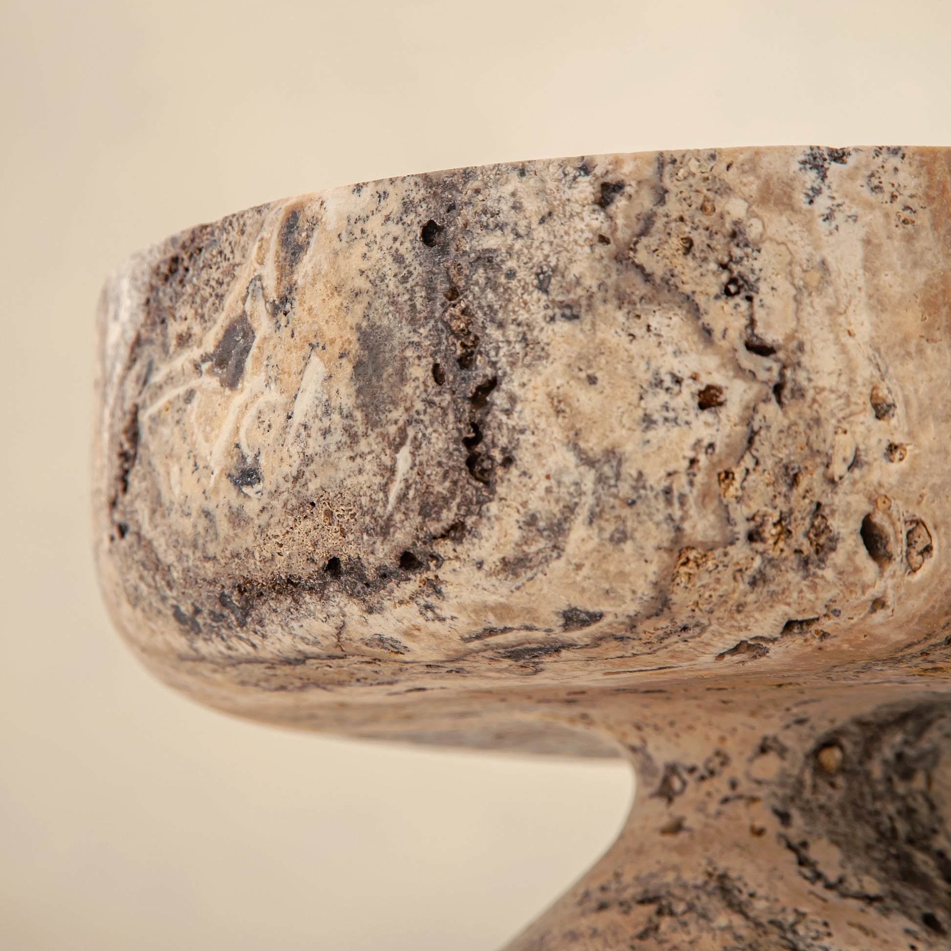 Handcrafted Gaia travertine bowl with wide shallow basin and pedestal base, featuring natural stone veining, by Uniiqo Studio