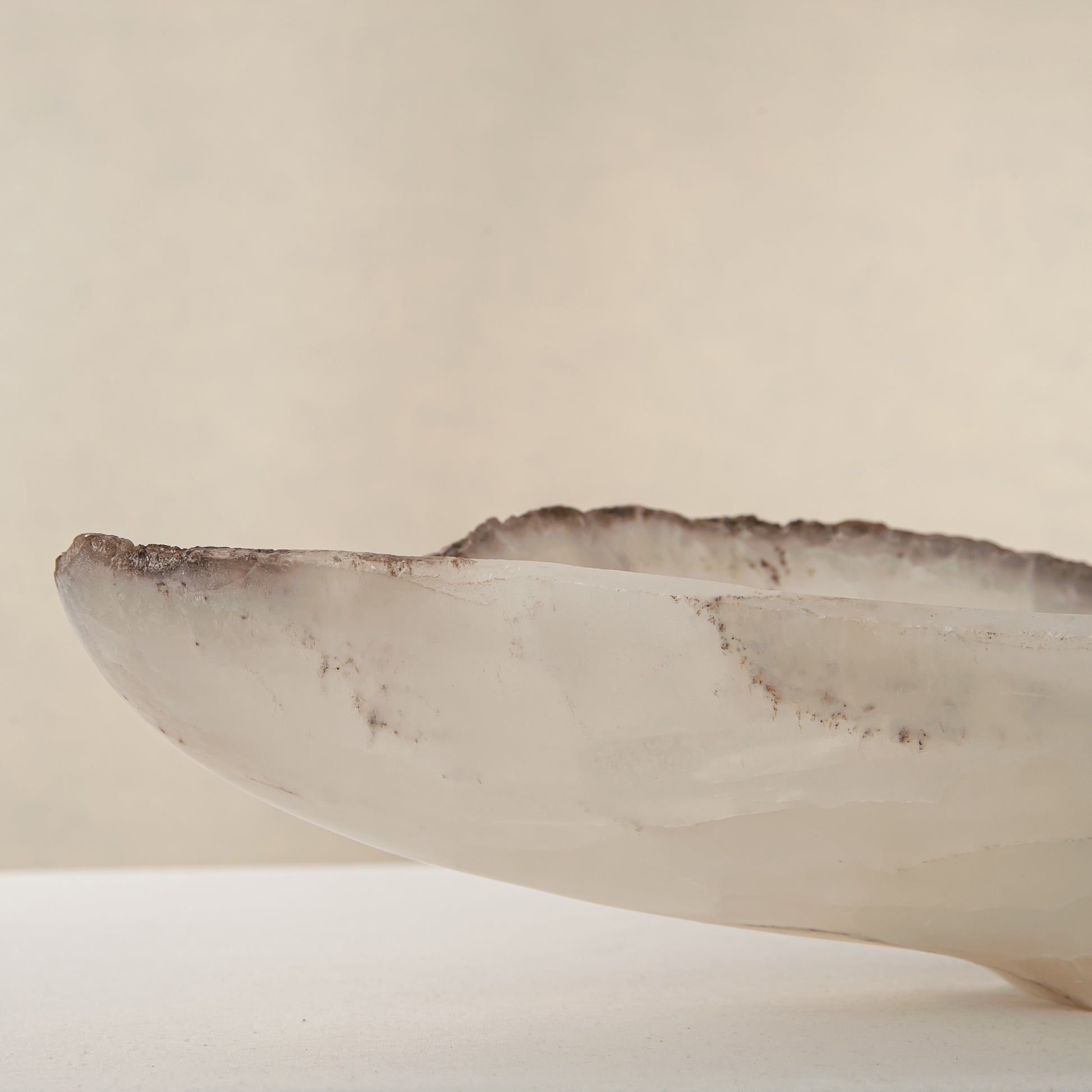 Handcrafted Grotta pale onyx tray with raw, geode-like broken rim, by Uniiqo Studio