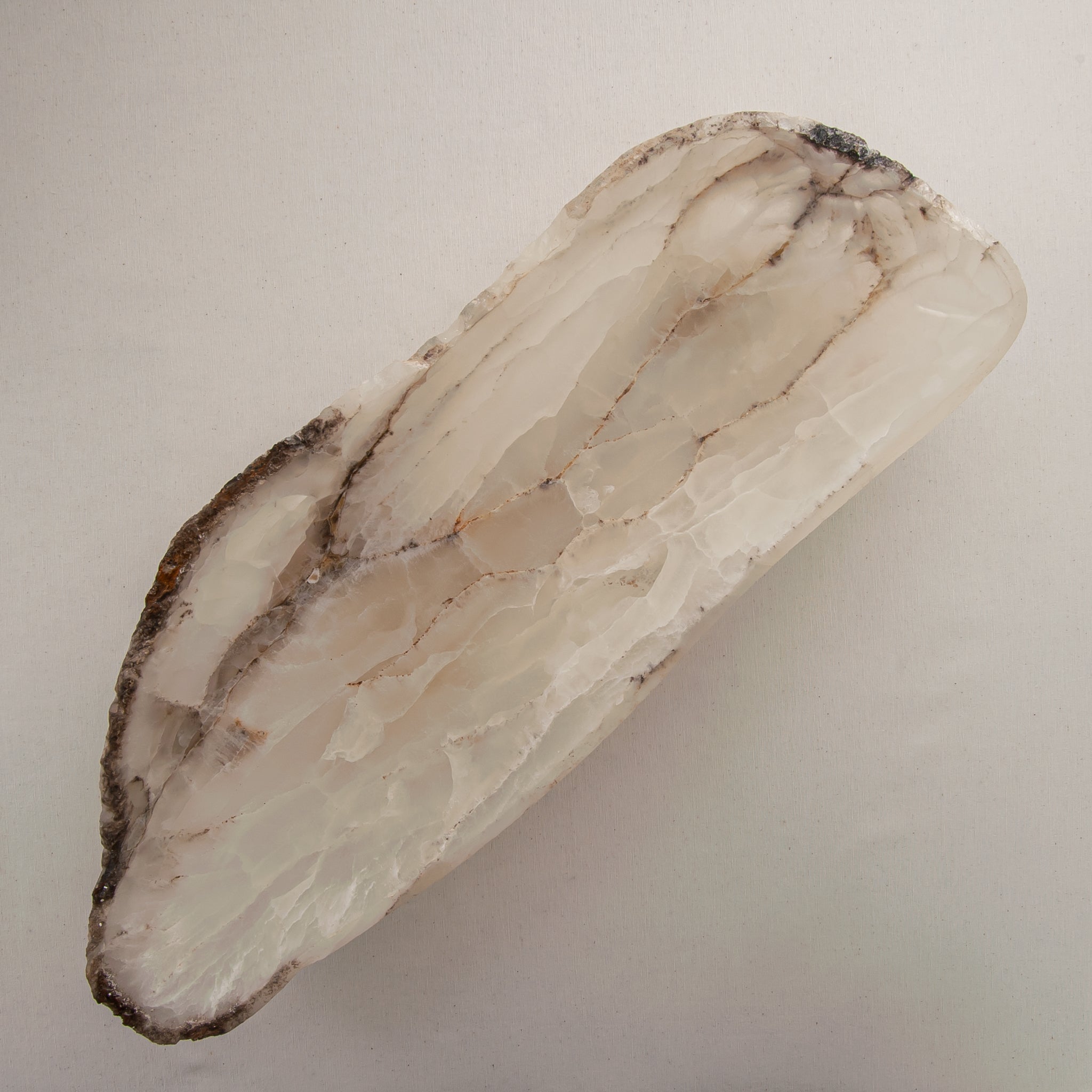 Handcrafted Grotta pale onyx tray with raw, geode-like broken rim, by Uniiqo Studio