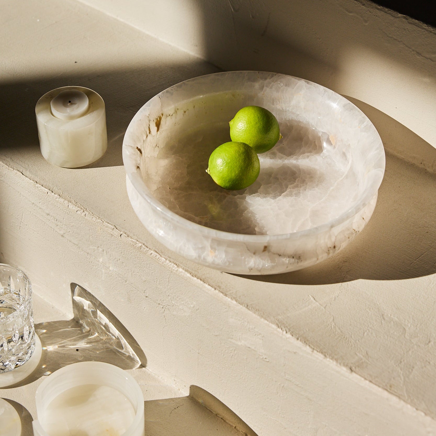 Unique white onyx bowl with translucent stone texture and sculptural curved form

